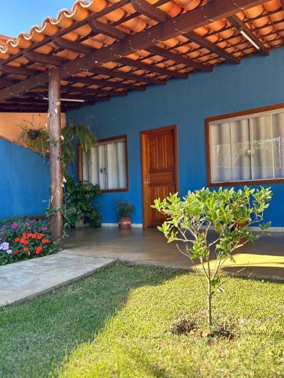 Varanda com pergolado de madeira, porta de madeira e jardim